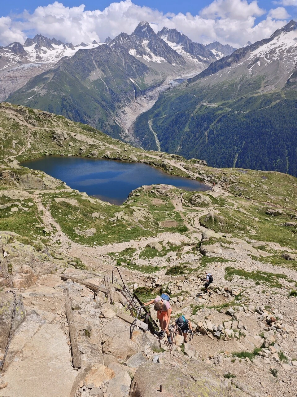 Randonneurs dans les échelles au-dessus des lacs des Chéserys, glacier d'Argentière en fond