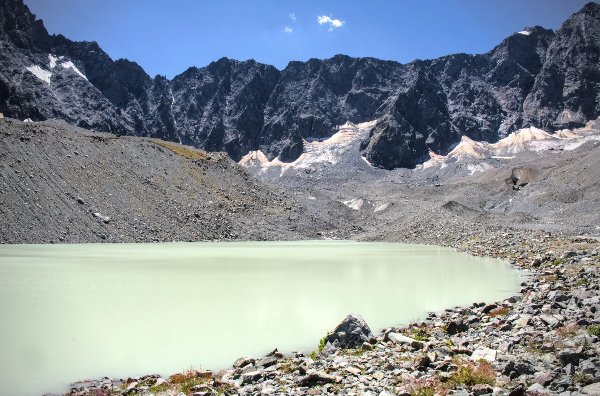 Le lac du Glacier d'Arsine et ses eaux laiteuses, cerné de moraines et de parois rocheuses